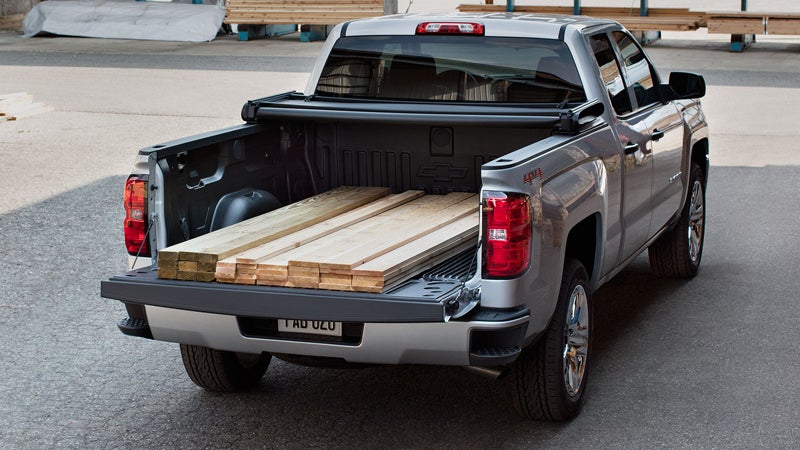 A Chevrolet Silverado 1500 loaded with wooden strips in the truck bed, showcasing its rugged design and capacity to carry heavy loads