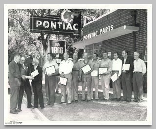 Vintage black and white photo of people holding frames.
