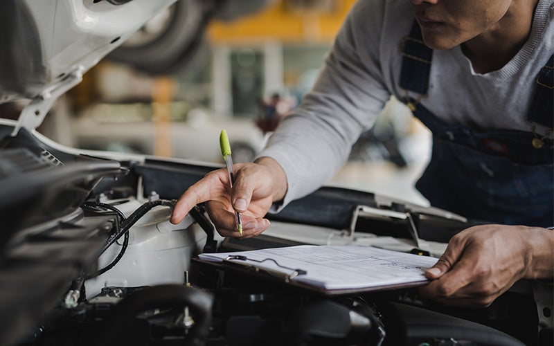 Technician Checking Car Engine